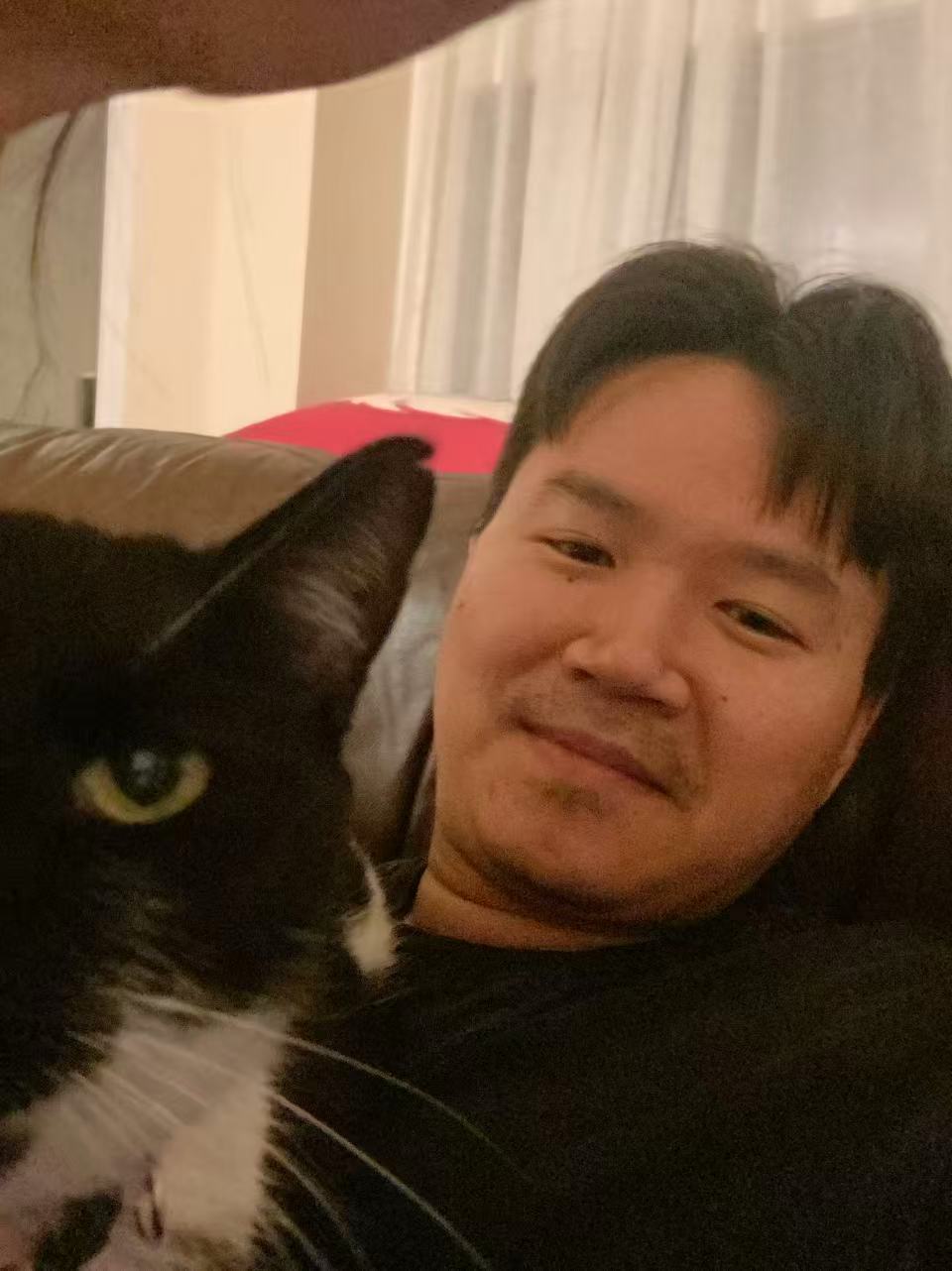 Shuofeng and Xiaobai the cat sharing a laptop